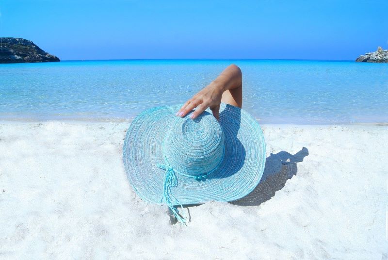 Blue sunhat on a beautiful sandy beach with the sea in the background
