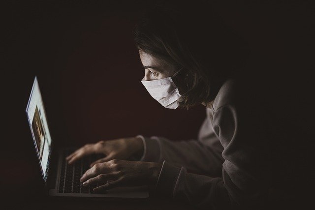 woman in mask on a laptop