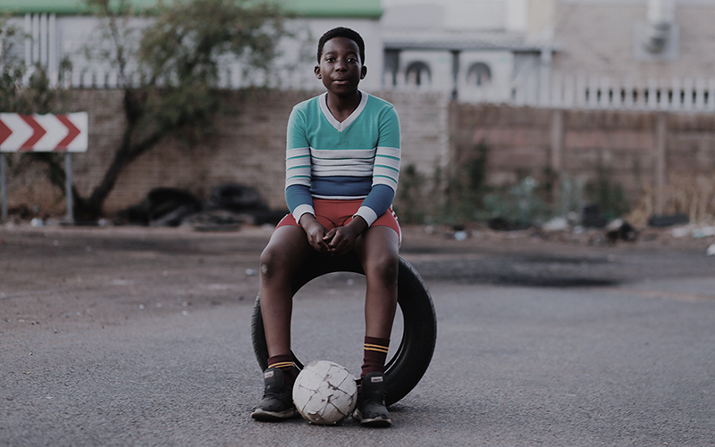 black boy sat on a vehicle tyre