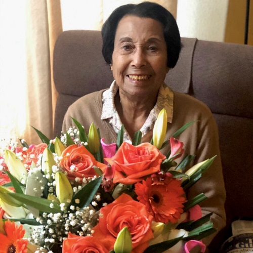 A photograph of a woman holding a bunch of flowers