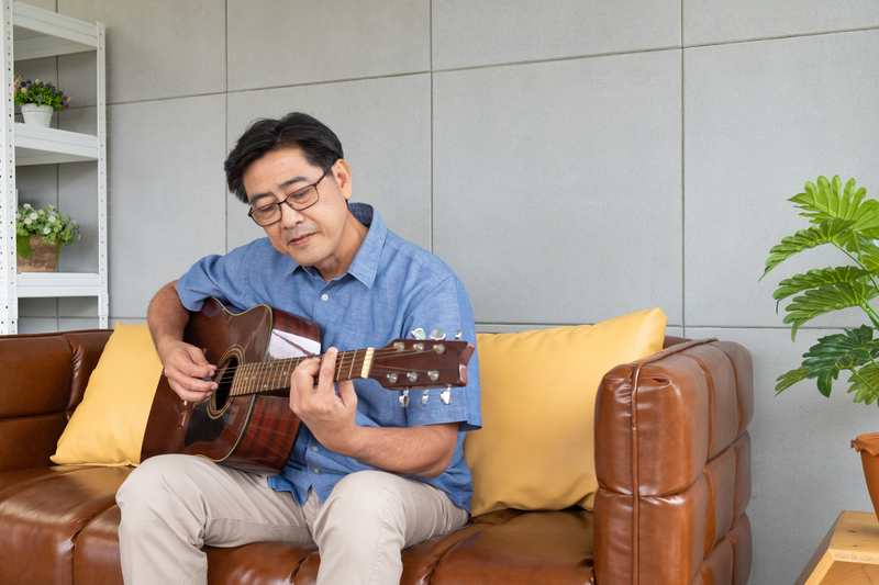 Elderly asian man on guitar