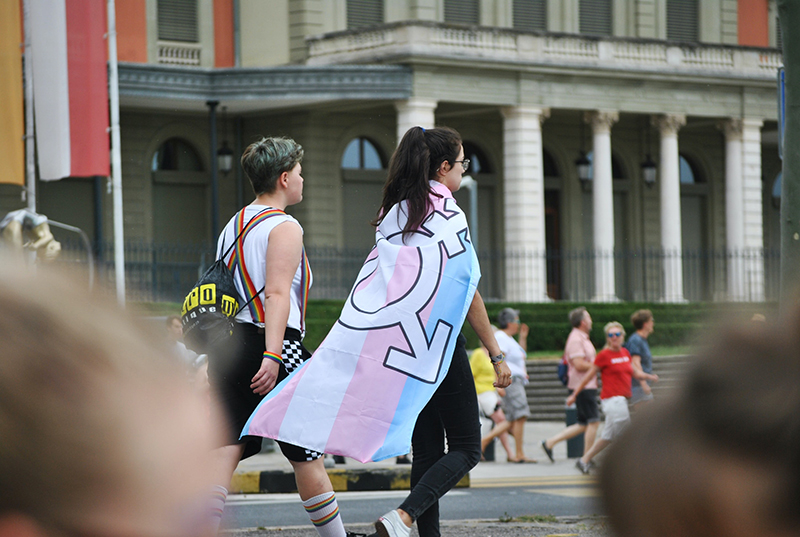 people walking on a road LGBTQ flag