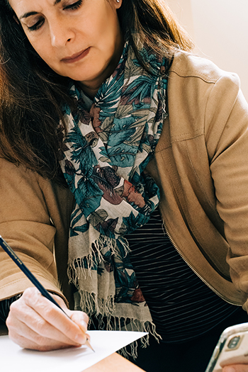 A Caucasian female writes on a piece of paper