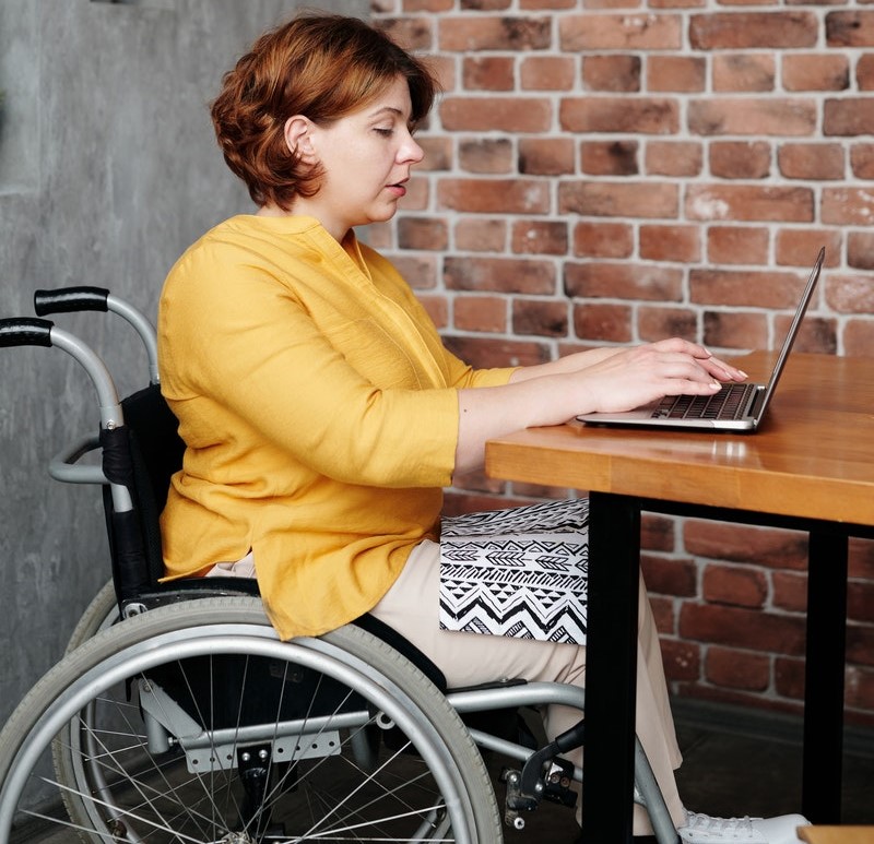 woman in a wheelchair working at a laptop