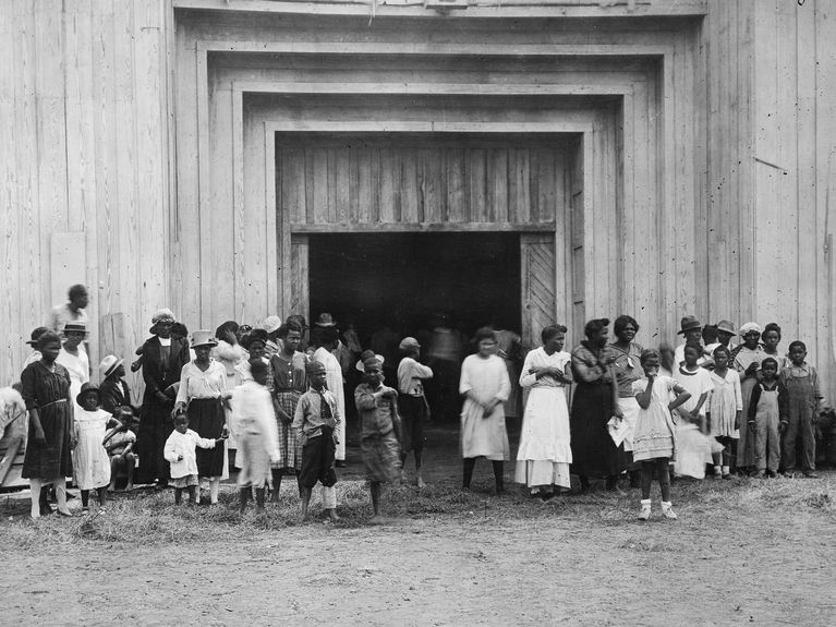 Black residents stand outside the entrance to a refugee camp on the fairgrounds in Tulsa after the massacre