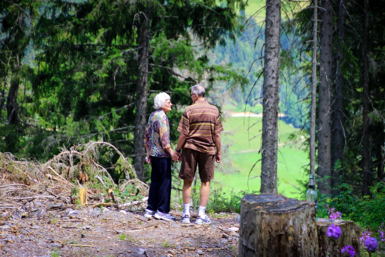 Two older people walking in the woods