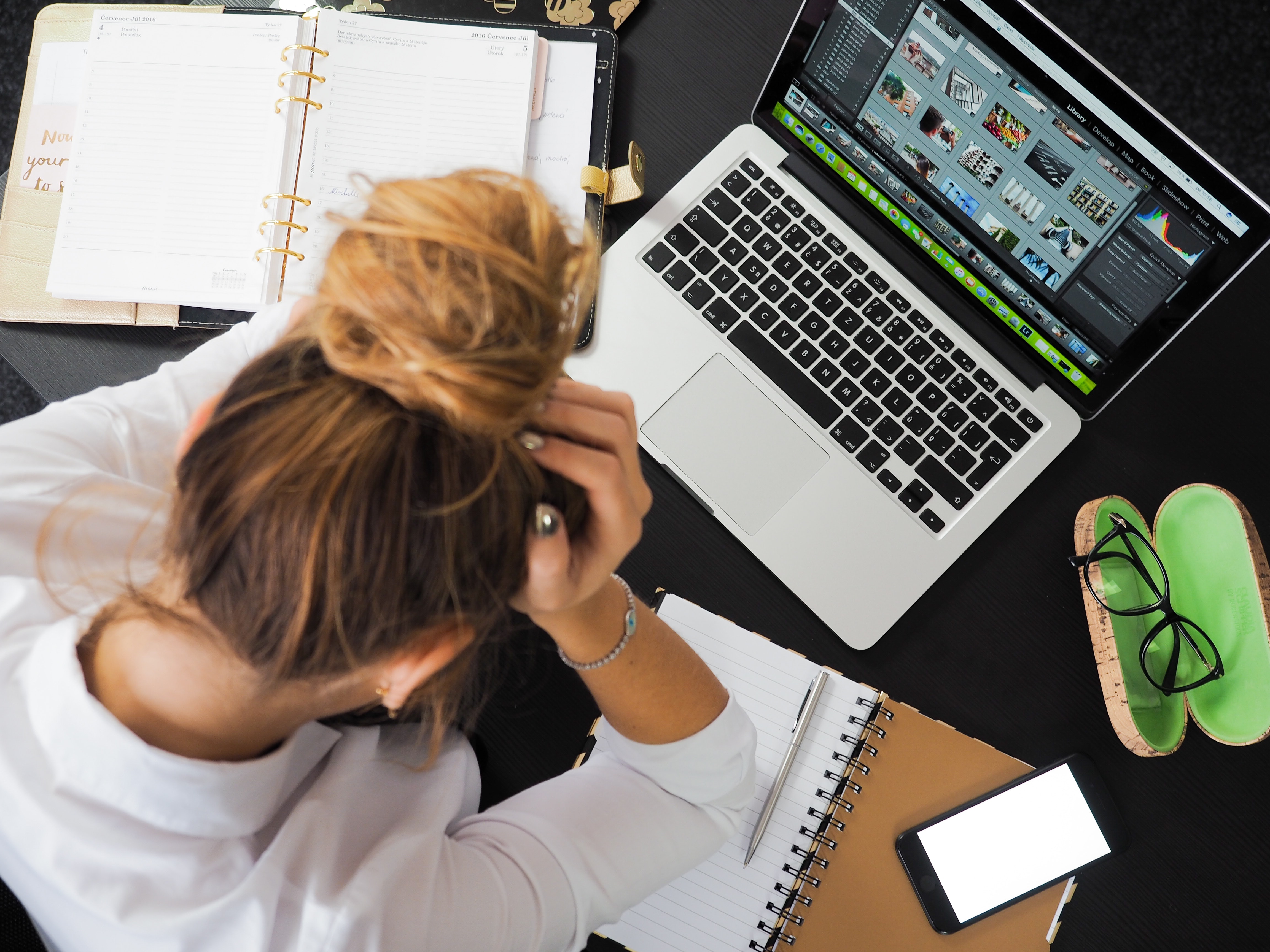 woman looking stressed in front of a mac book