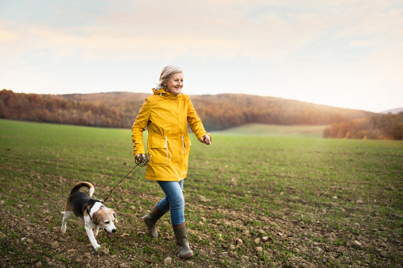 Senior woman with dog on a walk in an autumn nature