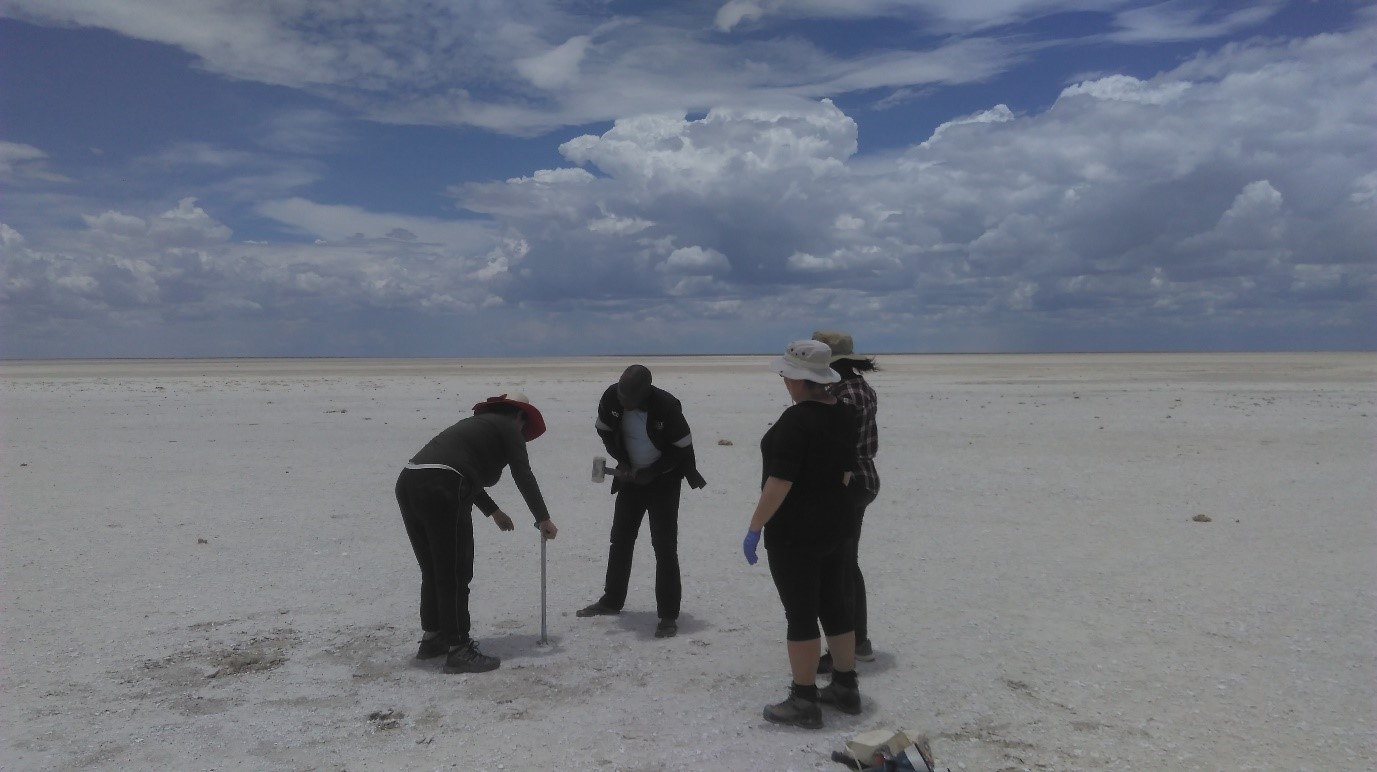 Dr Sevi Filippidou taking a core sample in the Mosu area of the South Sua Pan, helped by a geology student from BIUST