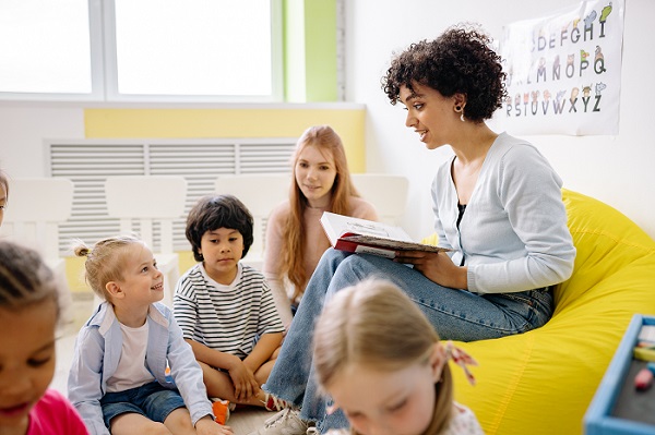 A photograph of a woman reading to a group of children
