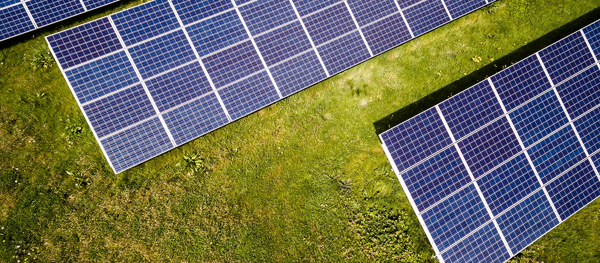 Photo of three solar panels in a field, bird's eye view