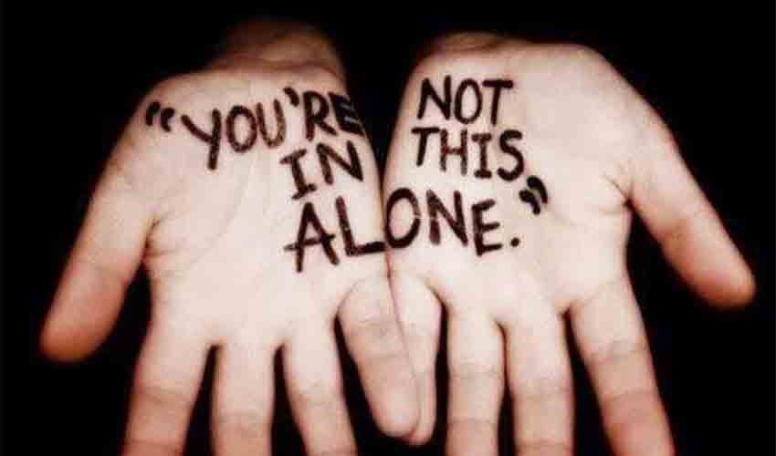 Hands with 'you're not alone in this' written on them