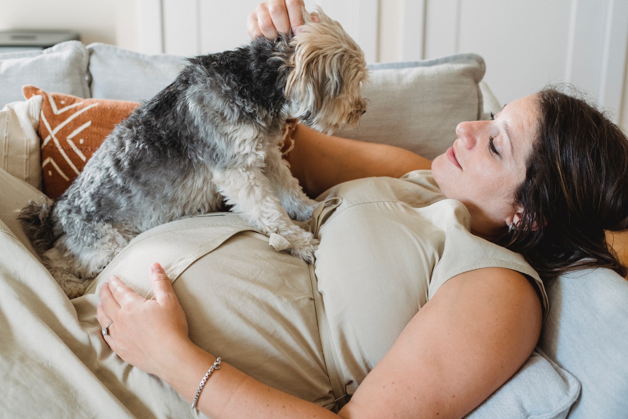 Pregnant woman cuddling a dog