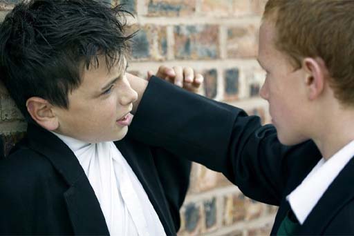A photograph of a school child being bullied by another school child.