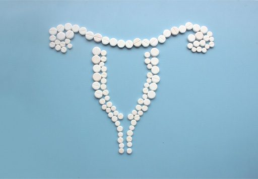 The image shows contraceptive pills organised to represent an outline of the uterus and the ovaries.