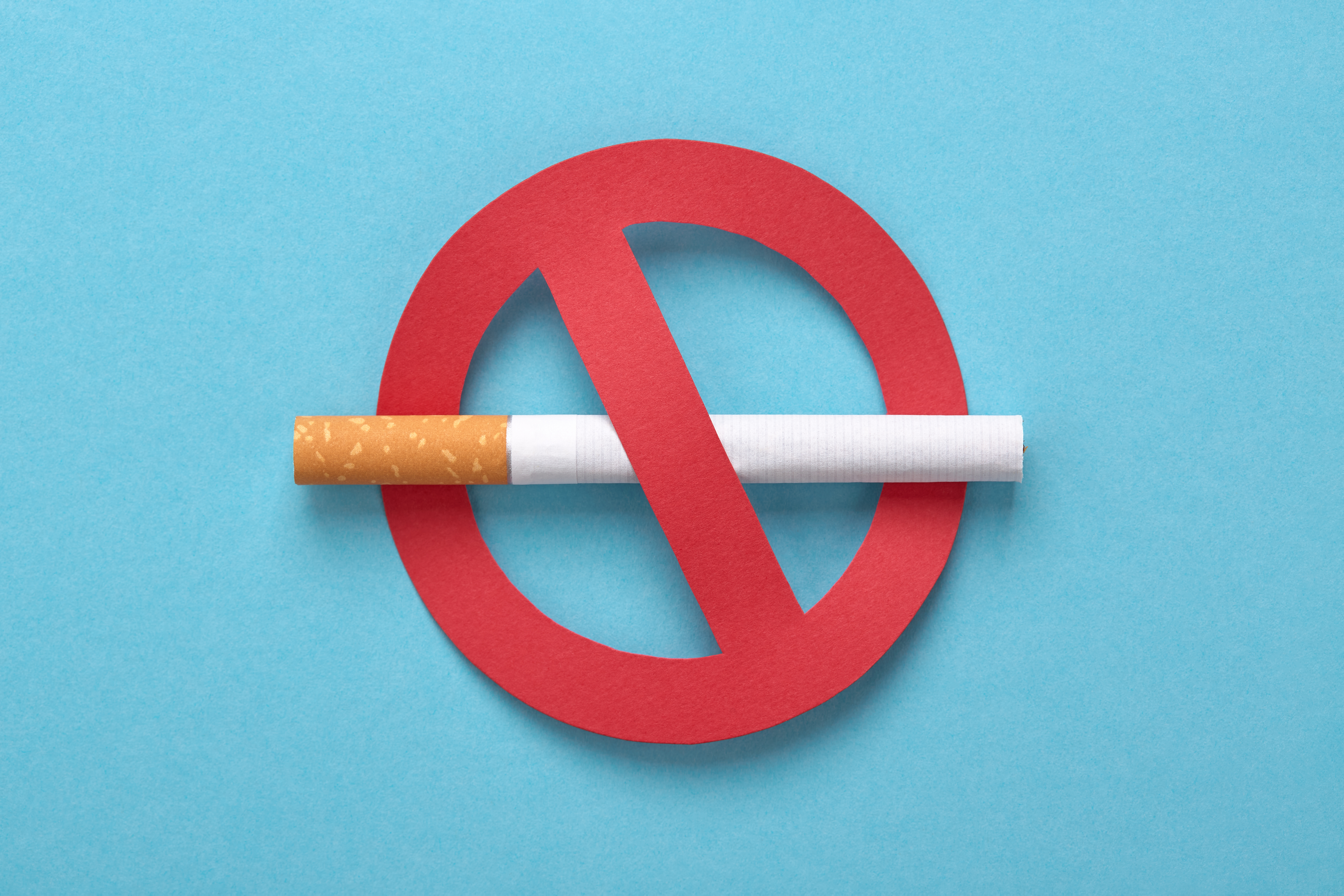 A photo of a real-life cigarette inside a red ban circular symbol