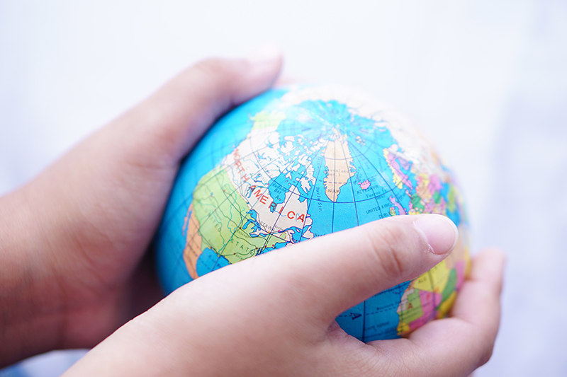 A pair of hands wrapped around a globe.