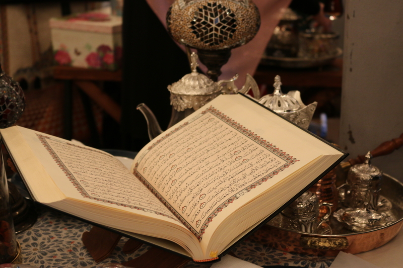 Open Quran with pots of tea during Ramadan.