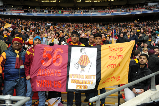 A photograph of a group of fans holding a sign saying ‘C’mon City, Wembley 2013’.