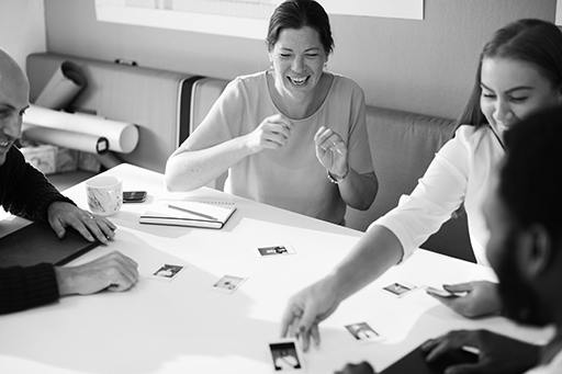 A photograph of four people at a table working with some visual cards.