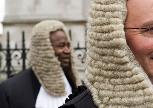 Photo of two judges. They are both wearing a judge wig and black robe.