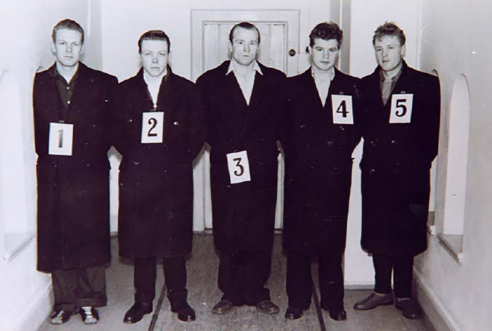 Photograph, black and white. Five Caucasian men in a police line-up.