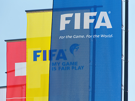 A photograph of a large flags with ‘FIFA. For the Game. For the World’ on them.
