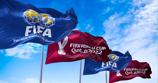 A photograph of four flags with FIFA written on them.