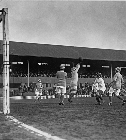 A black-and-white photograph of women playing football.