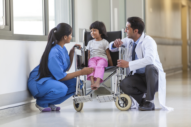 nurse, doctor and a young child patient in a wheelchair