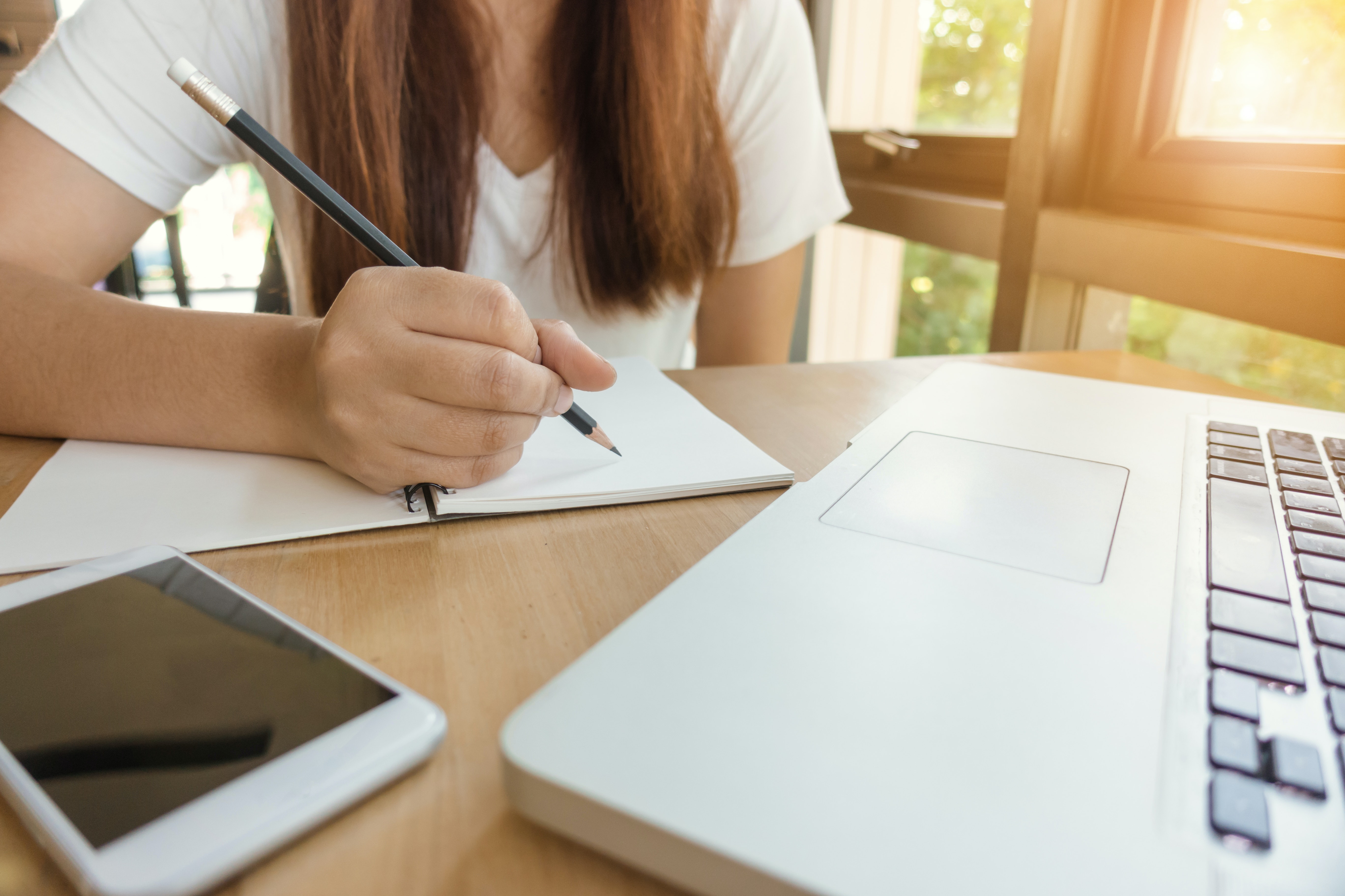 woman sitting at a desk about to write