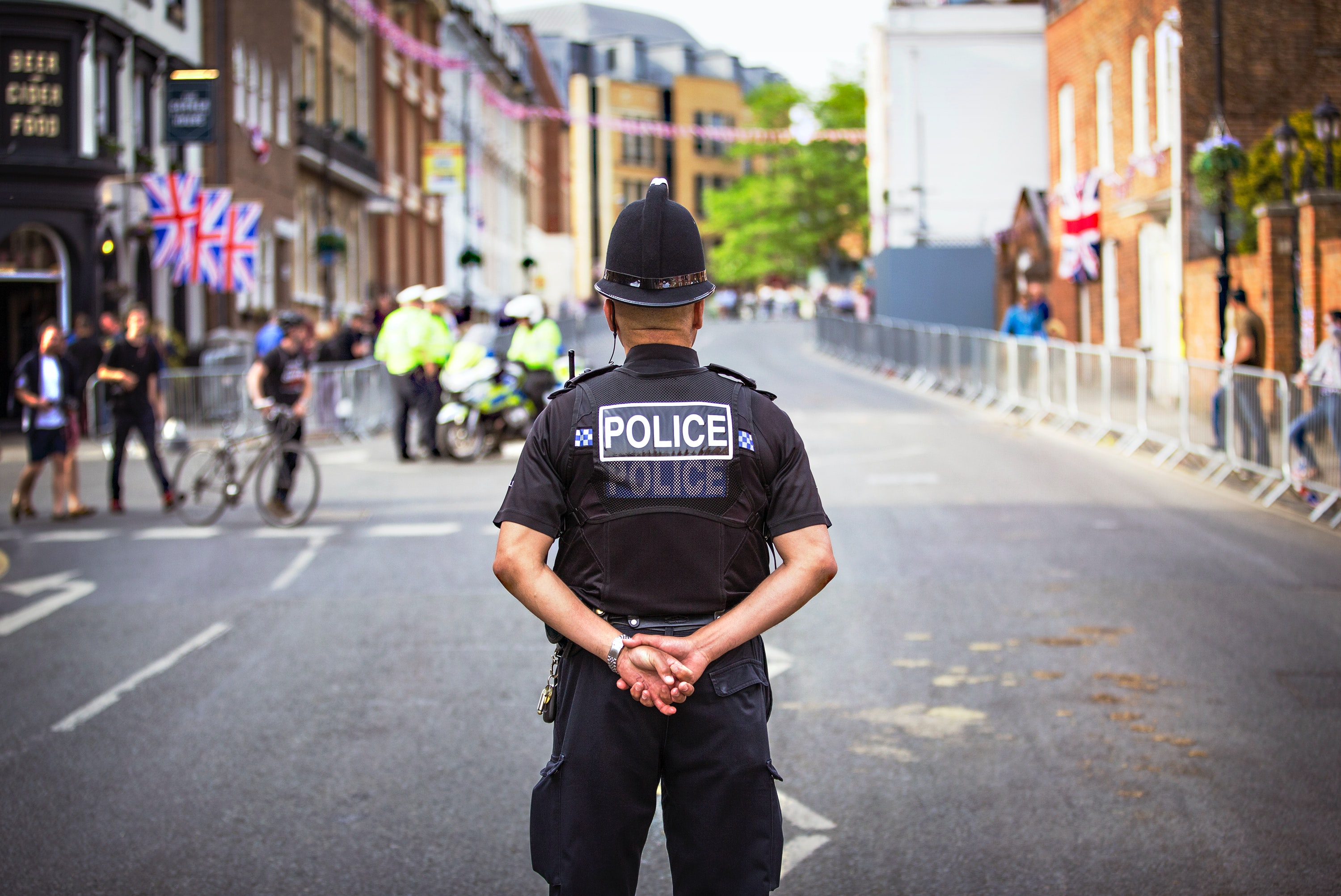 A police man standing with his hands behind his back.