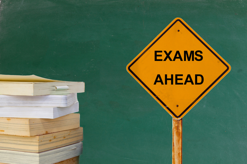 Sign saying 'EXAMS AHEAD' next to books