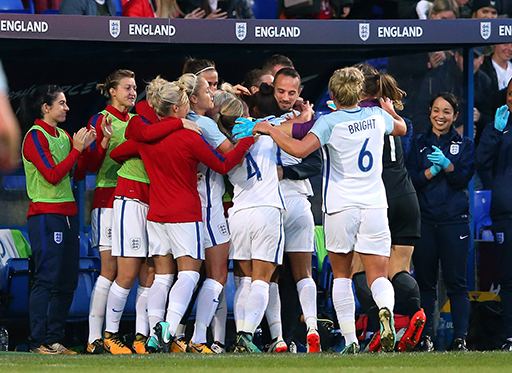 A photograph of a group of football players celebrating together.