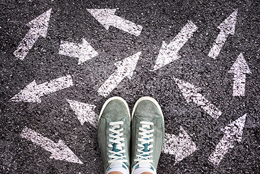 A photograph of a pair of feet surrounded by arrows going in different directions.