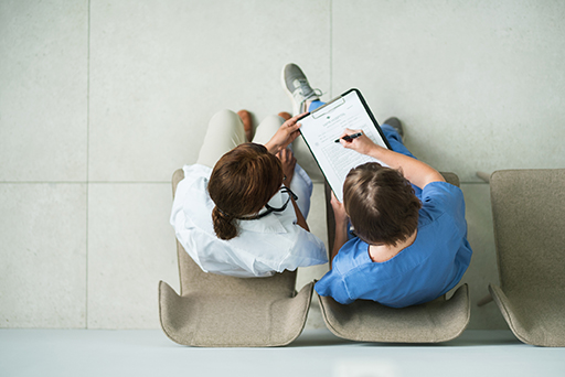 A photograph of two healthcare workers in discussion.
