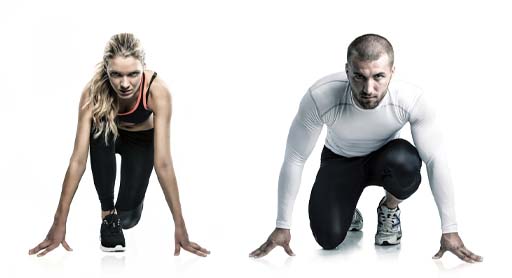 The image shows two athletes, one male and one female in a sprint start position. They are both looking at the camera and there is a gap between the two athletes.