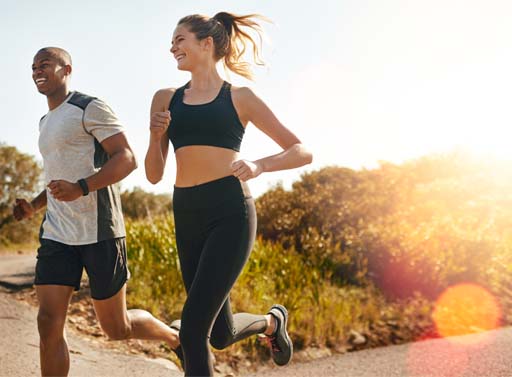 The image shows two runners running on a country road. They are both smiling and enjoying themselves.