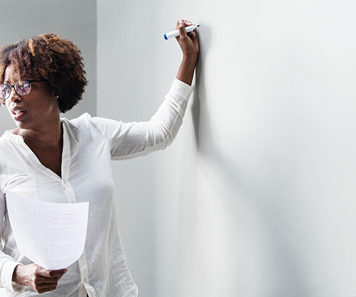 A photograph of someone teaching using a whiteboard.