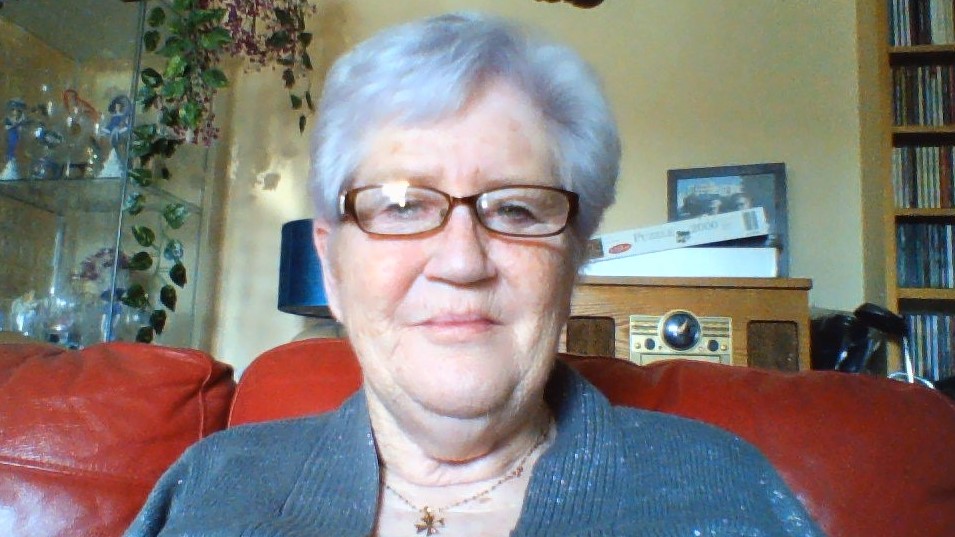 photo of Janet Cassidy, sitting in her home, looking into the camera.