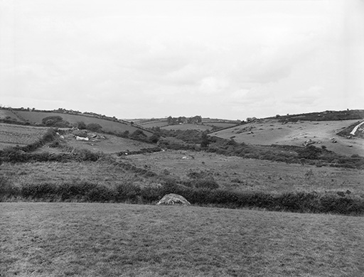 A black and white photograph of a landscape. There are three low hills in the photograph and several fields which are divided by hedgerows.