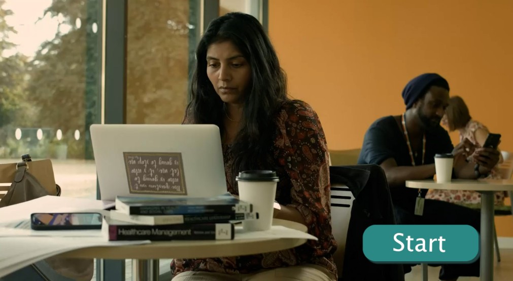 A lady sitting down in cafe working on a laptop.