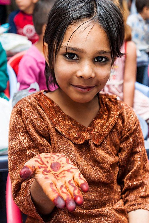 Young Afghan girl showing her henna artwork
