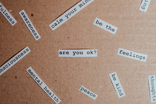 A number of cut out bits paper with phrases and words on, such as ‘are you ok?’, ‘feelings’, and ‘mental health’.