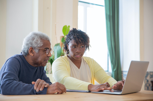 Two people looking at a laptop.