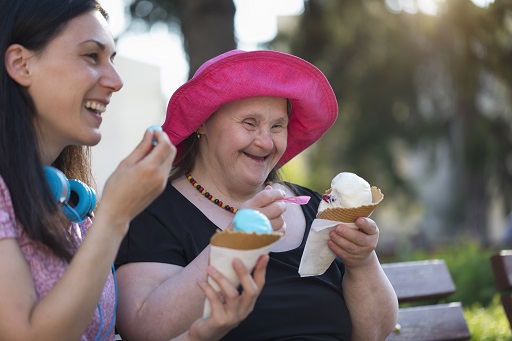 An image of two people sitting on a bench eating ice cream.