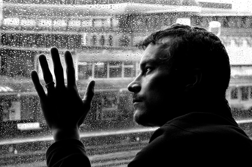 A person looking out of a rainy window.