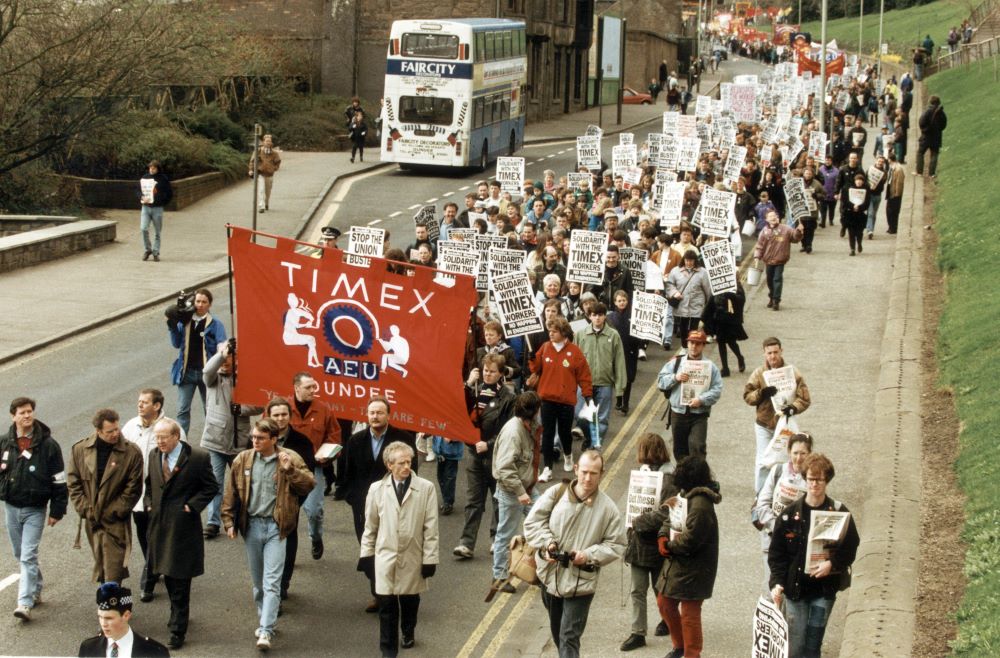 A big group of people marching with banners and placards. 
