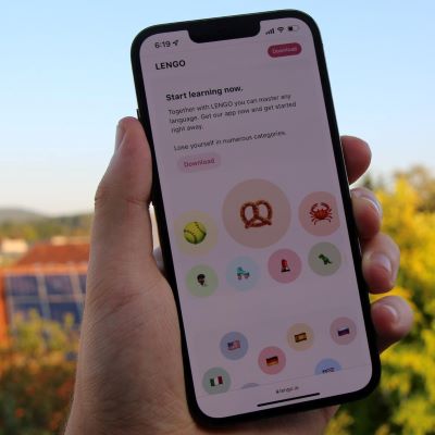 A hand holding up a smart phone, with a translation app open.