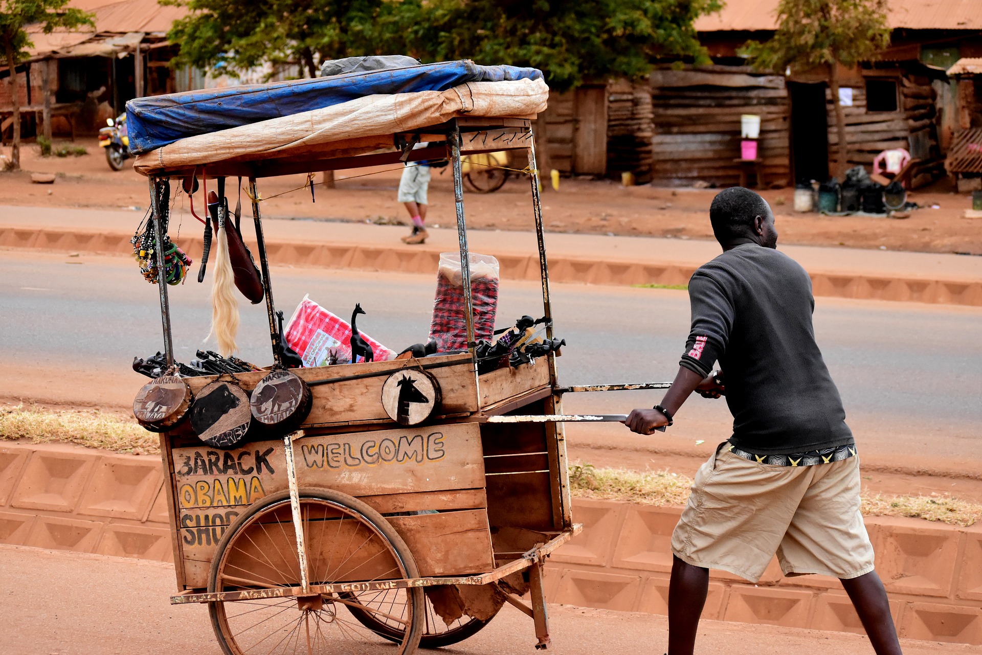 A street vendor in Tanzania, pushing his cart along the road. 